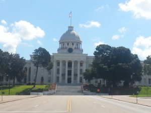 Schoolnik visiting the State Capitol Montgomery Alabama. Stately white building, with cupula with blue skies.