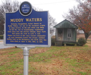 Muddy Waters Home Rolling Fork, Mississippi. Blue historical marker in front of small, green shotgun house.