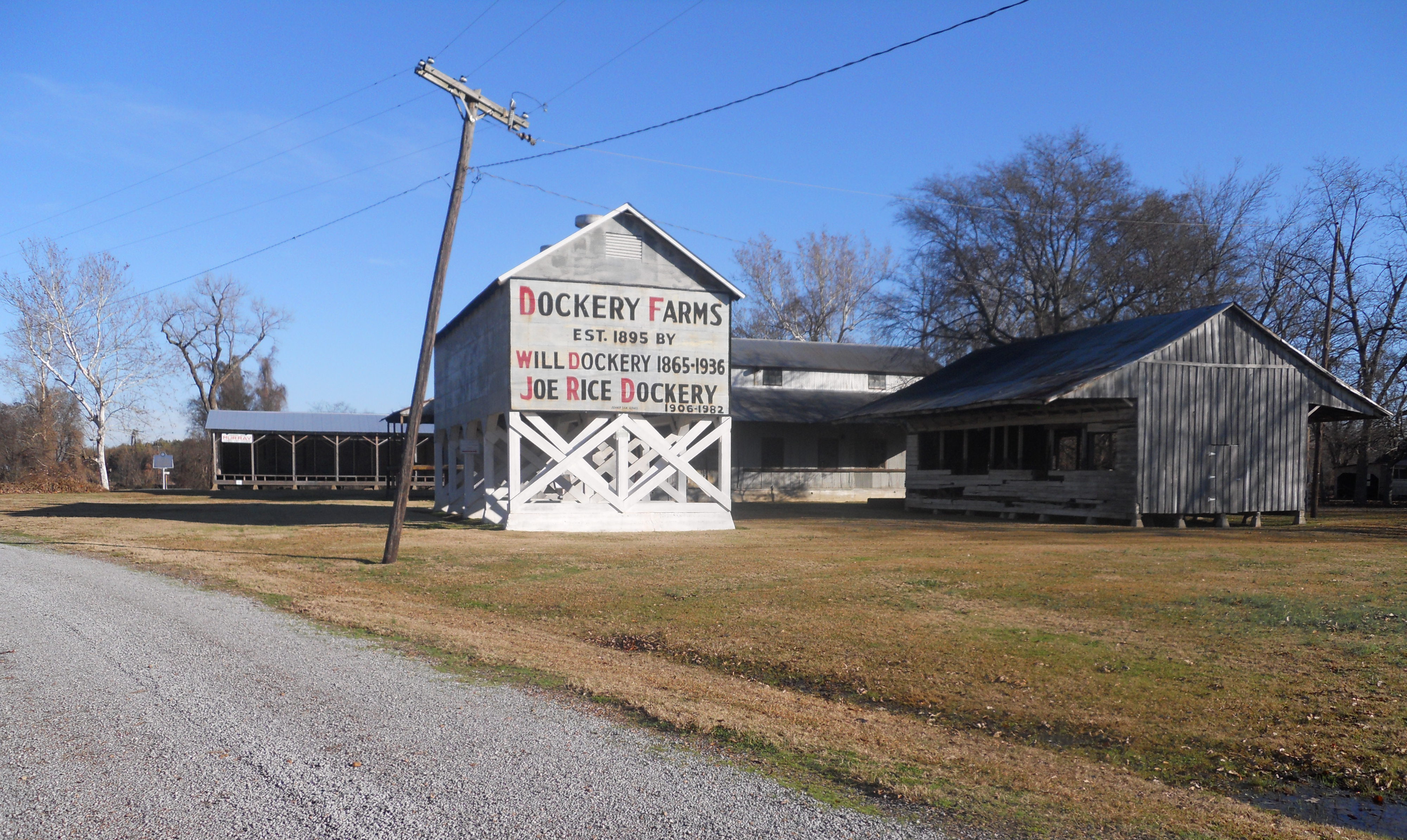 Dockery Farms. Between Cleveland, MS, and Ruleville, MS. Farm buildings under a blue sky.