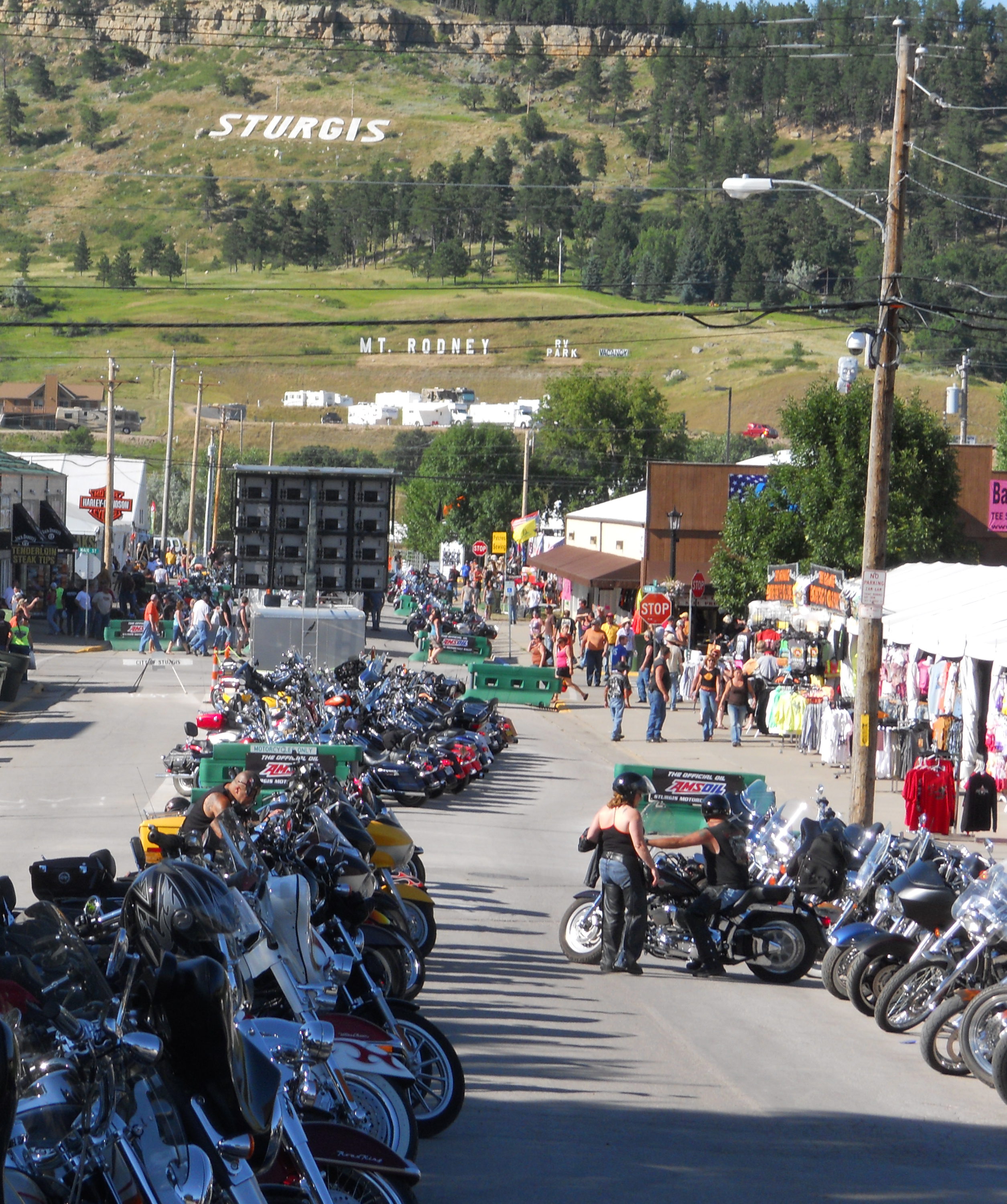 Sturgis Motorcycle Rally Sturgis, South Dakota. Row of motorcycles with Stugis sign on hill in distance